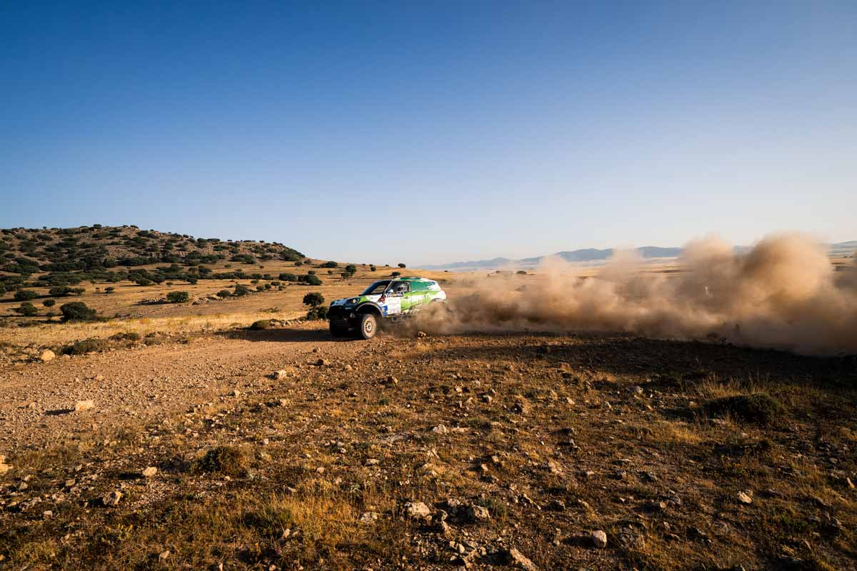 Coche de rally raid levantando polvo en una pista de tierra durante la Baja Aragón